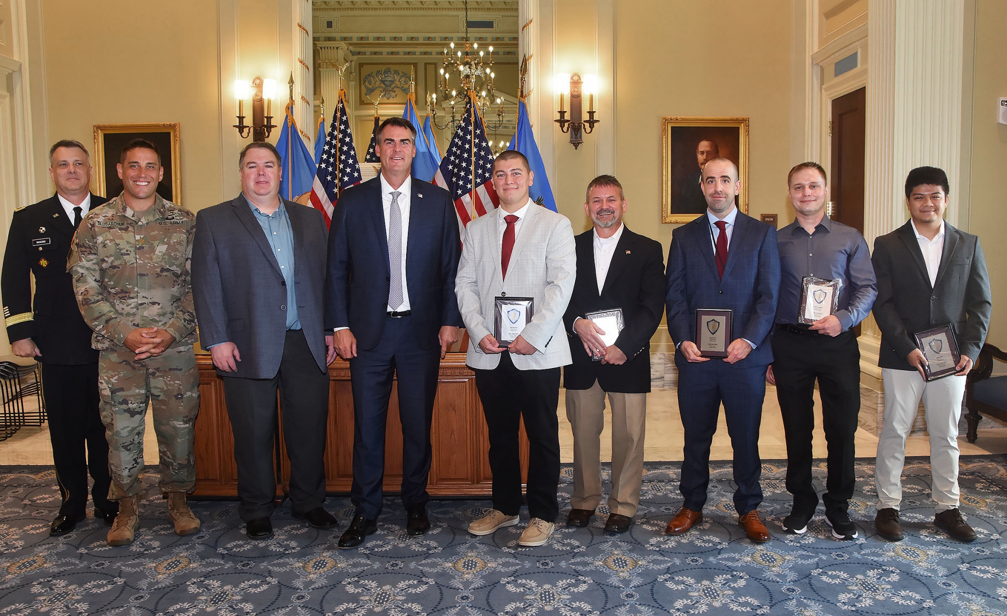 Pictured left to right: General Thomas Mancino; Major Dan Slusarchuk; Michael Toland, State Chief Information Security Officer; Oklahoma Gov. Kevin Sitt; Tyler Womack, OMES Security Engineer; John Phillips, OMES Hurt and Incident Response Manager; OMES Senior Security Engineer; Anton Bondarev, OMES Senior Security Engineer; Kim Baciles, OMES Senior Security Engineer.
