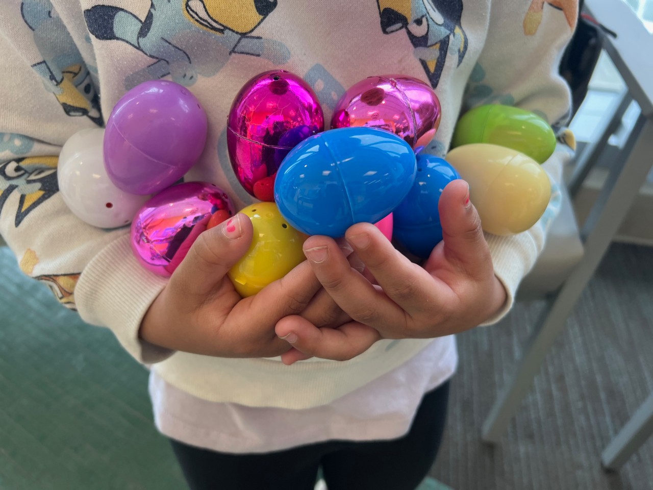 A handful of Easter eggs held by a child.