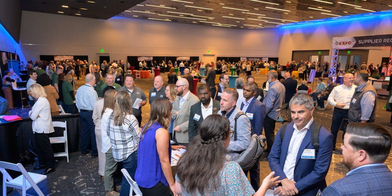 Overview of the expo ballroom displaying a large crowd