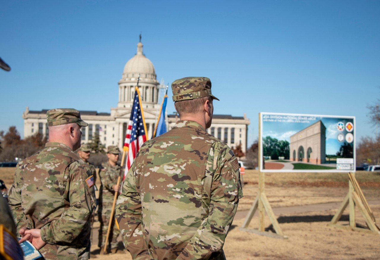 Military personnel stand in front of the State Capitol at the 45th Division National Guard Arch and Park groundbreaking ceremony.