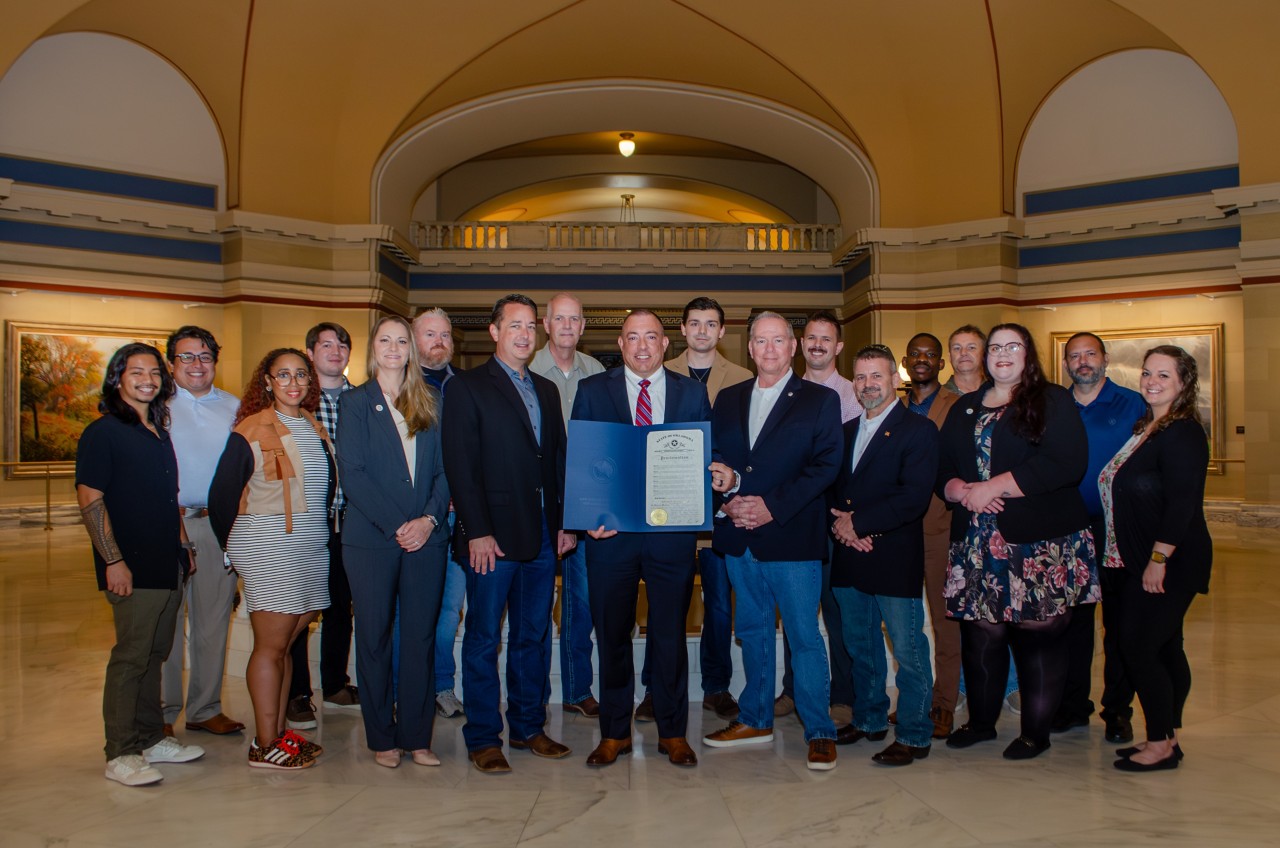 State Chief Information Officer Dan Cronin is joined by the OMES OK-ISAC and Oklahoma Cyber Command teams holding the proclamation for the 2025 Cybersecurity Awareness Month in Oklahoma. (Photo by Maddy Remington, OMES Outreach.)
