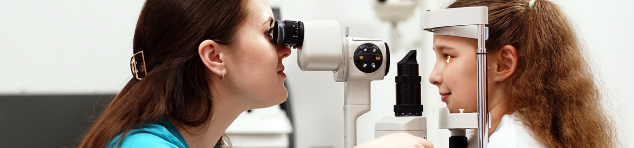 Examination of the child using a slit lamp. Microscope and focused light source. A device for high-precision examination of the eye to determine the condition of the lens.