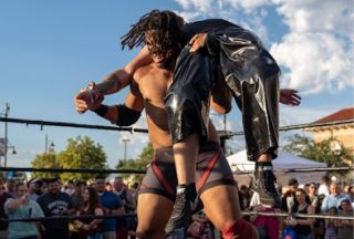 Wrestler with his opponent over his should.