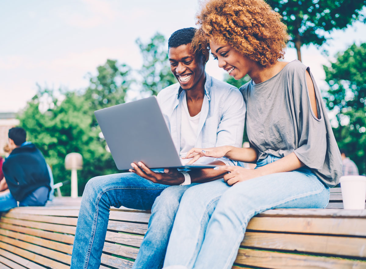 Two people viewing a video on a laptop