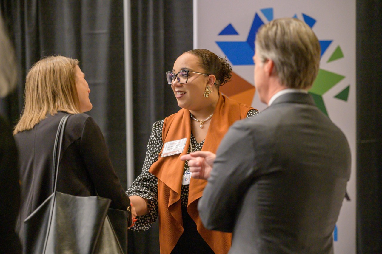 Oklahoma Human Services employee shaking hands with suppliers at Human Services booth during the 2023 State Suppliers Expo.