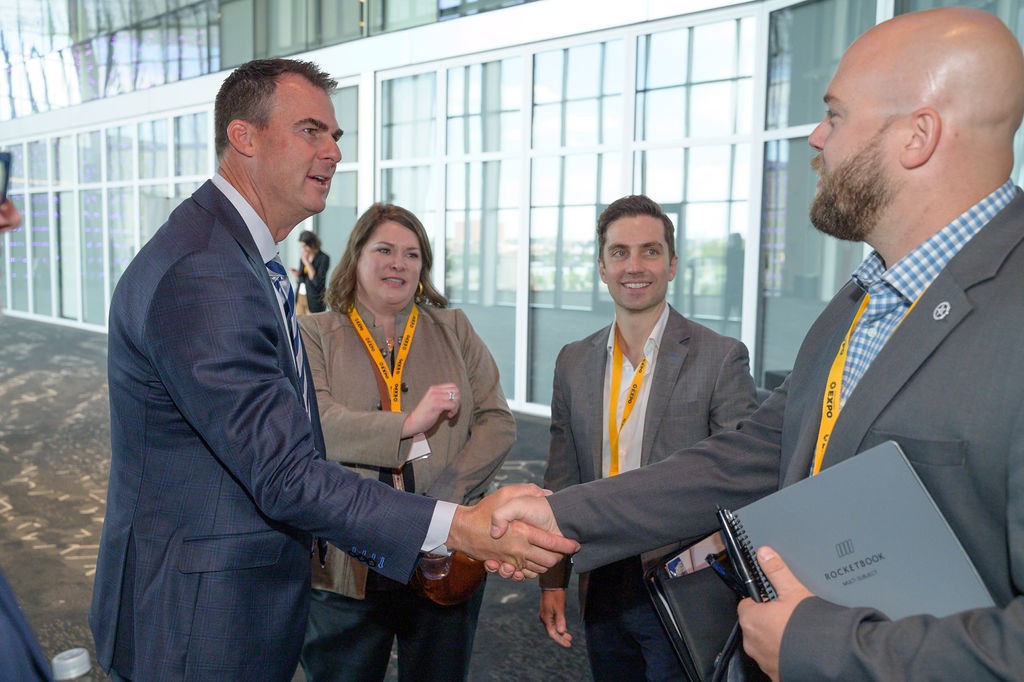 Gov. Kevin Stitt shaking hands with attendees