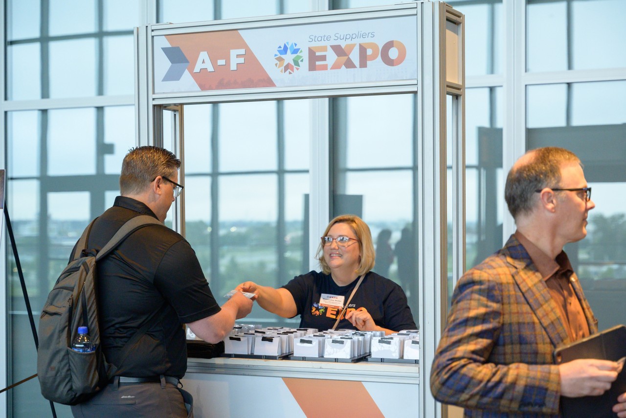 2023 Expo staff helping attendee check in at kiosk