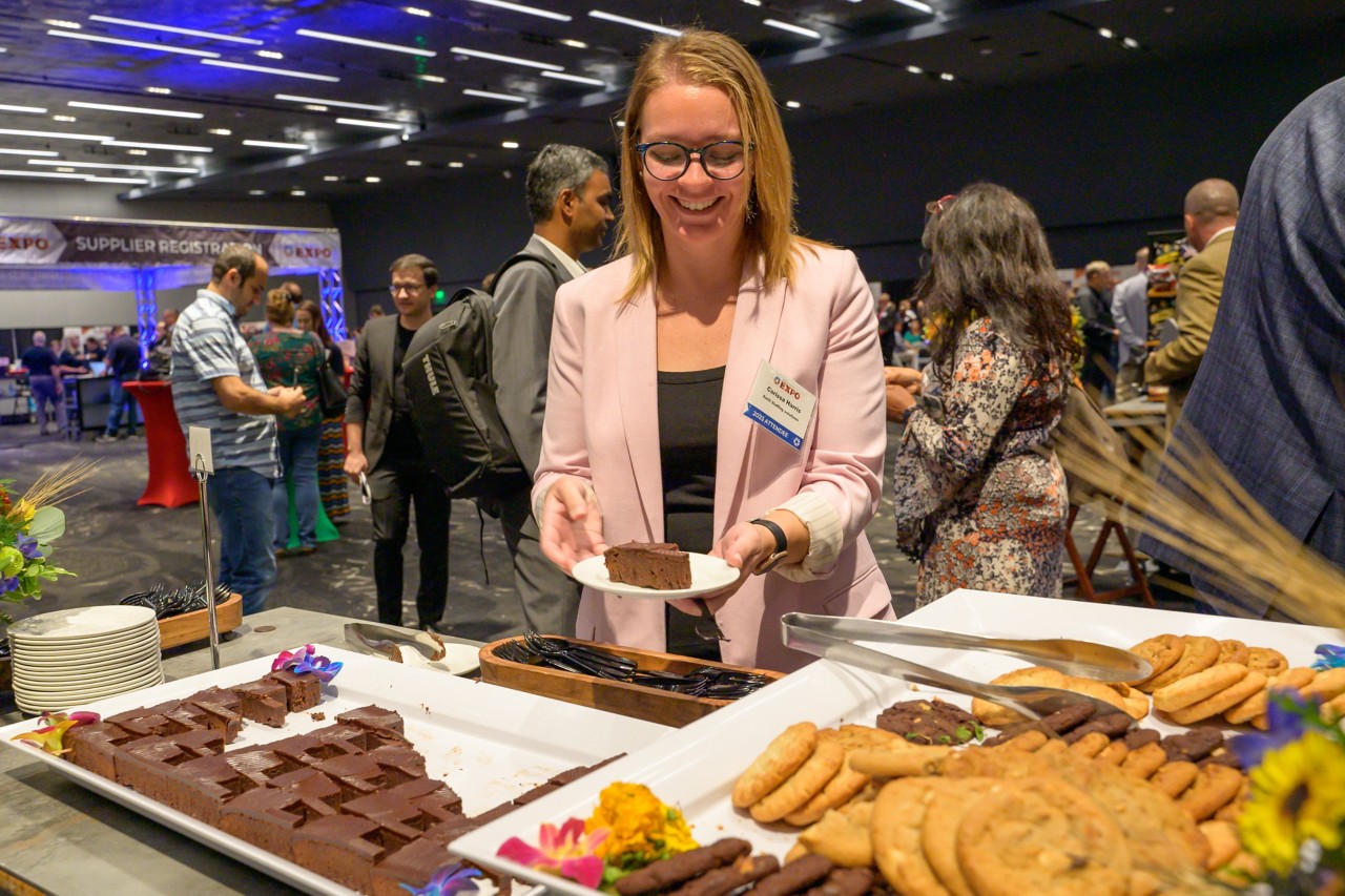 Attendee smiling with an Oklahoma-shaped brownie on a plate.