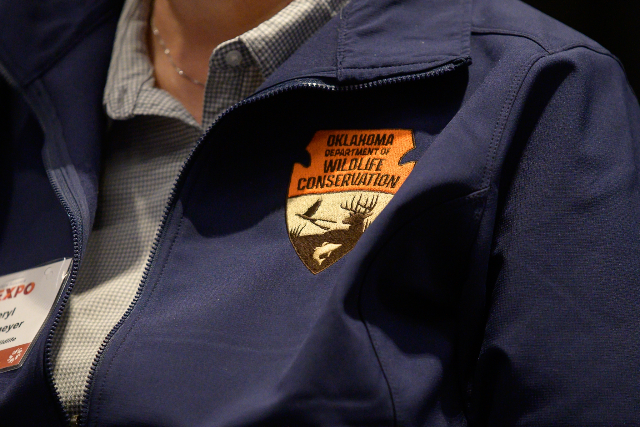 Oklahoma Department of Wildlife Conservation patch embroidered on a navy blue jacket.