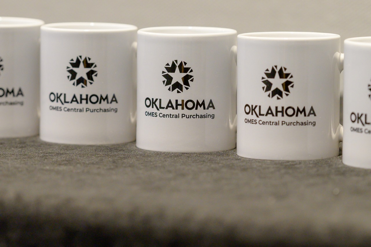 Oklahoma OMES Central Purchasing mugs at the Expo swag table.