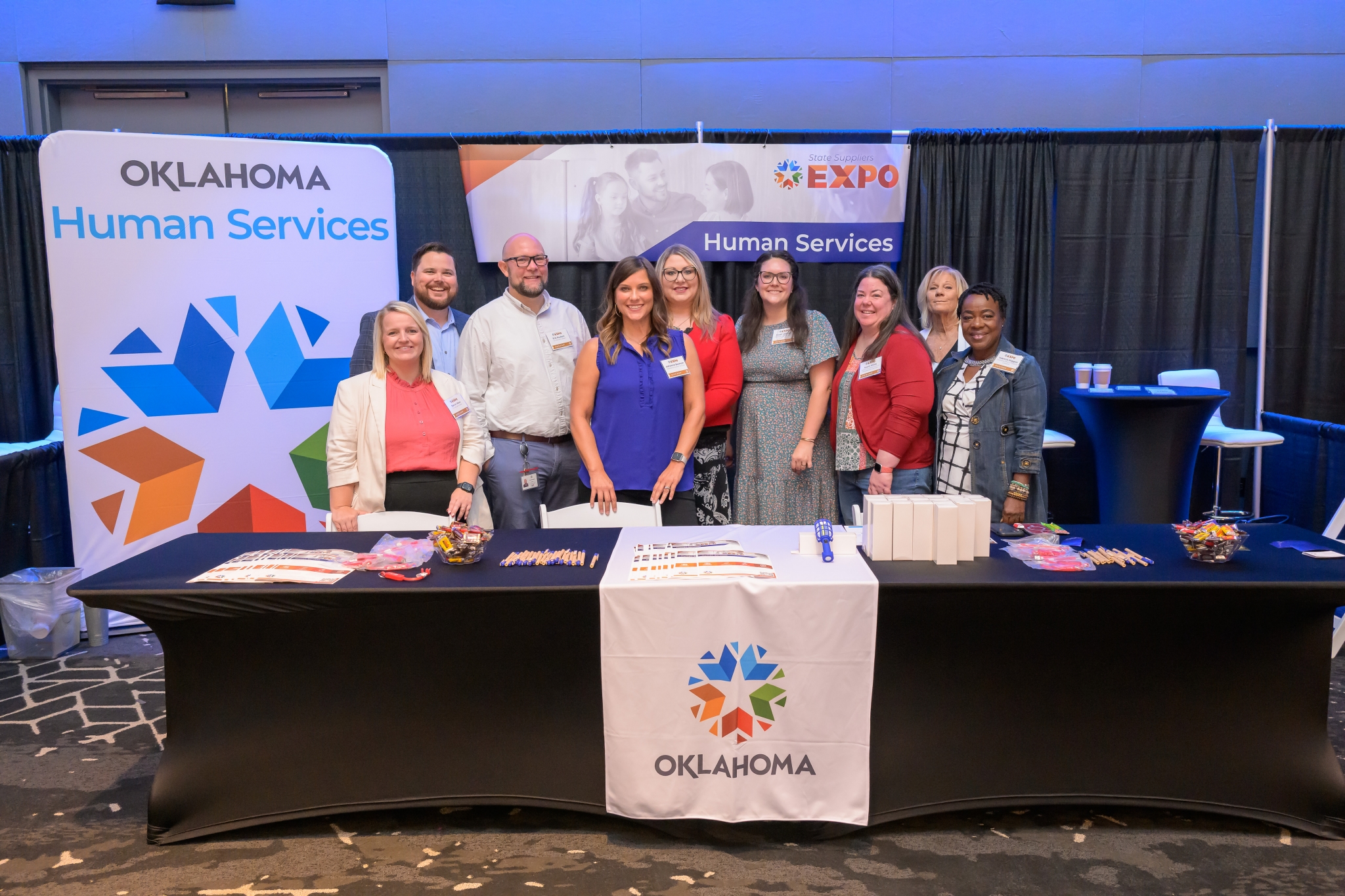 Nine staff members stand at the Human Services booth