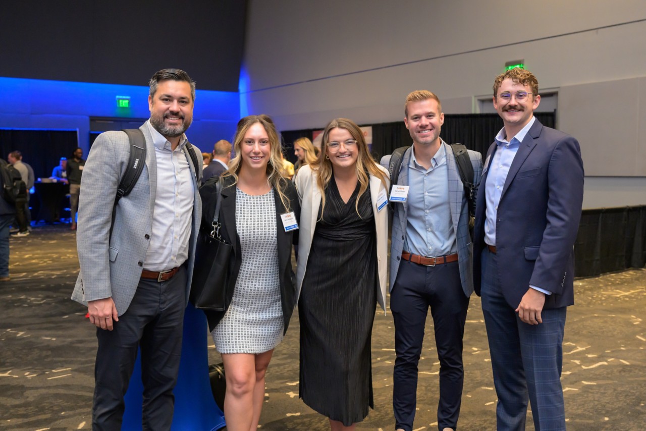 Five attendees smiling for a photo