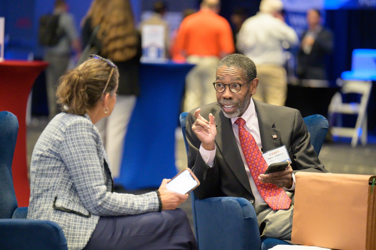 Two attendees visit in the OKC Convention Center ballroom during the 2024 State Suppliers Expo.