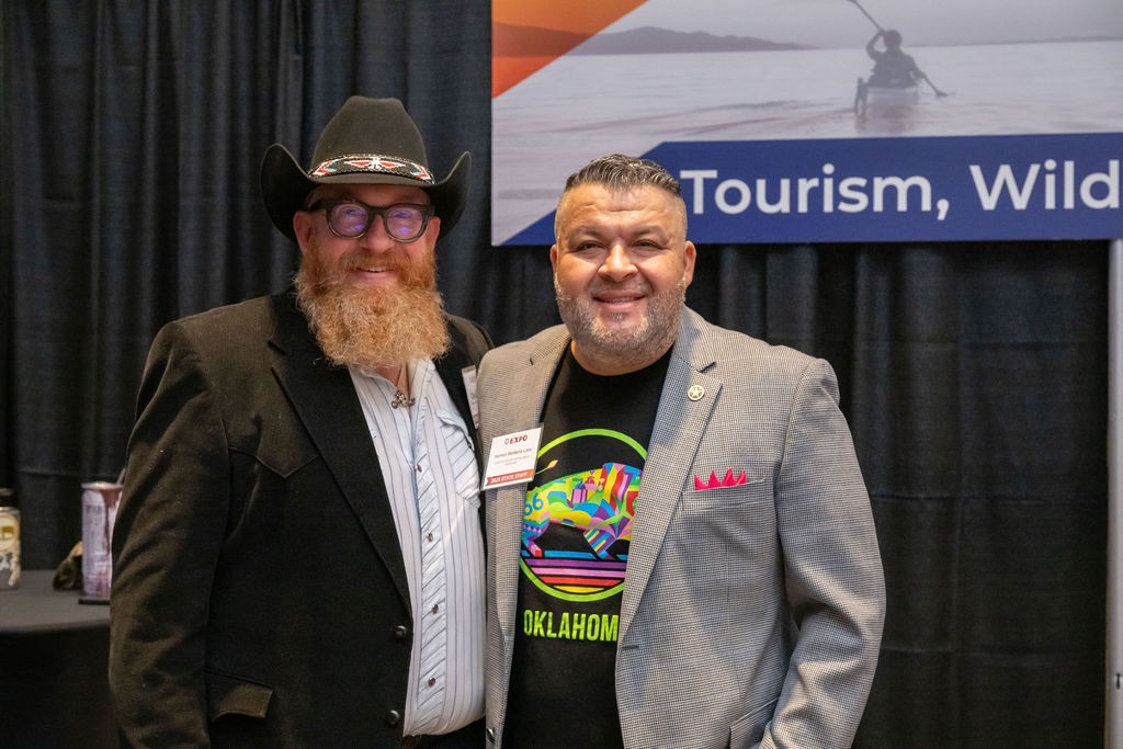 Two OTRD employees smile at Tourism, Wildlife and Heritage booth
