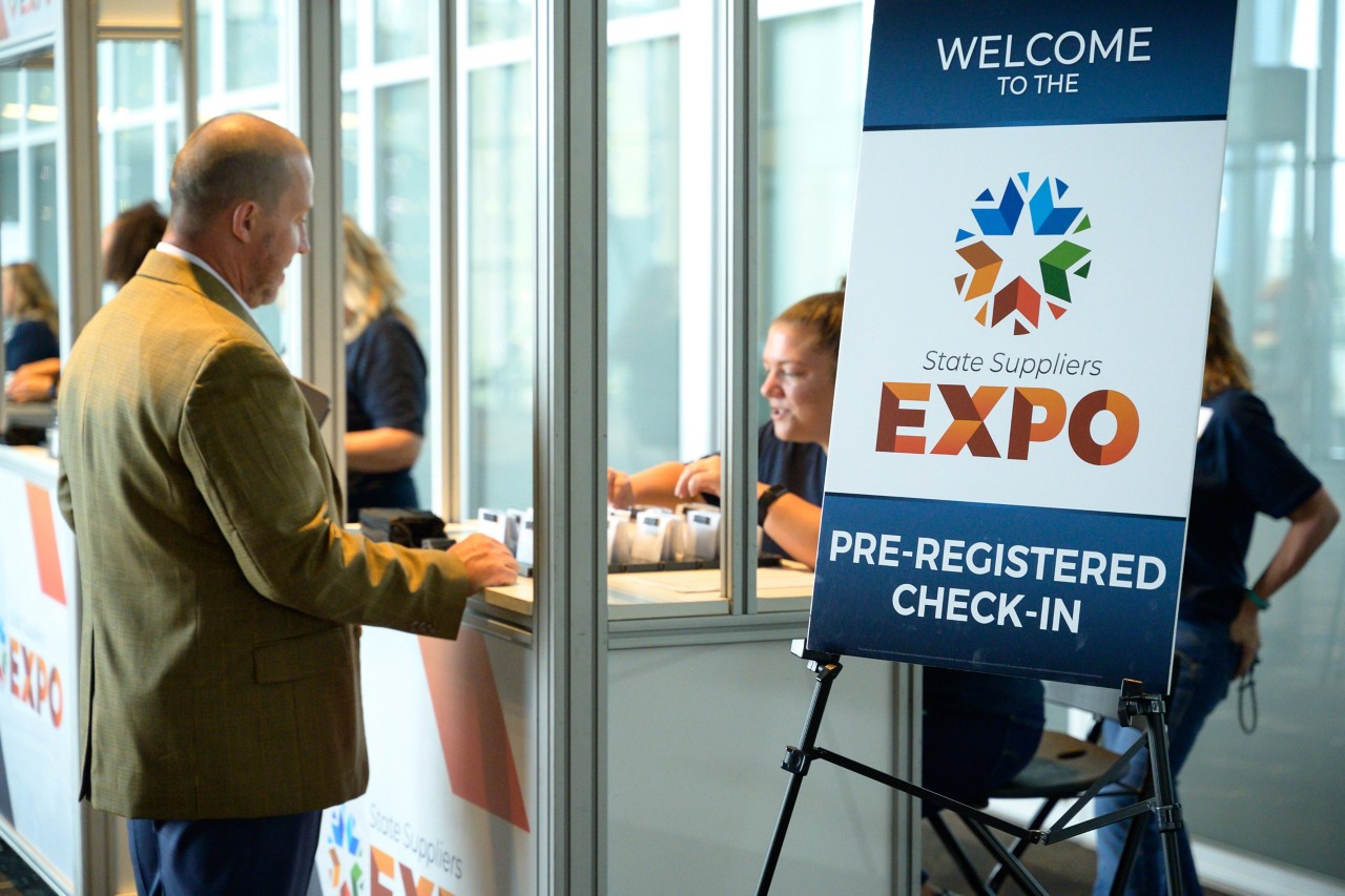 Man picks up badge at pre-registered check-in kiosk at the 2023 State Suppliers Expo.